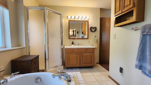 full bathroom featuring a shower stall, tile patterned floors, a garden tub, and vanity