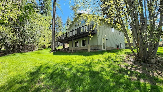 rear view of property featuring a yard and a deck