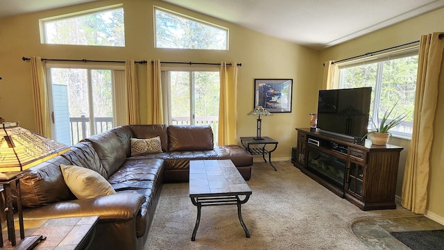 living area with light colored carpet, plenty of natural light, baseboards, and lofted ceiling