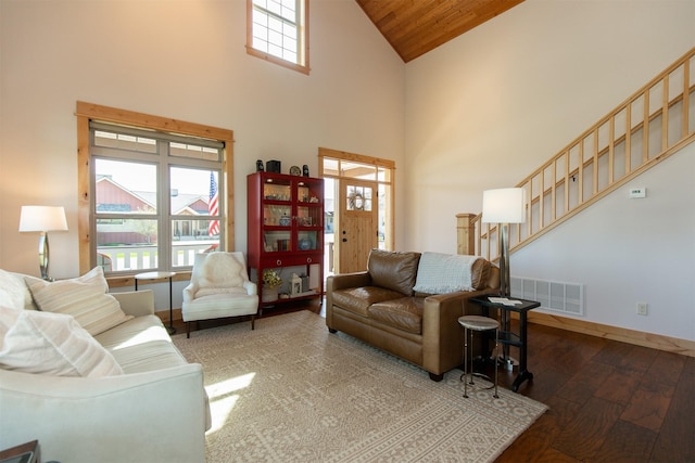 living room featuring stairway, baseboards, visible vents, high vaulted ceiling, and hardwood / wood-style floors