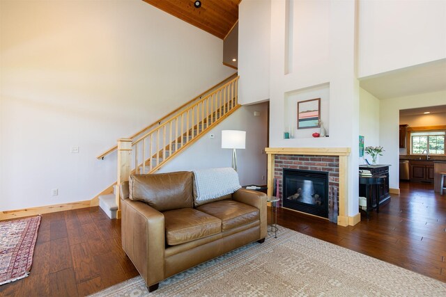living room with baseboards, stairs, wood-type flooring, and high vaulted ceiling