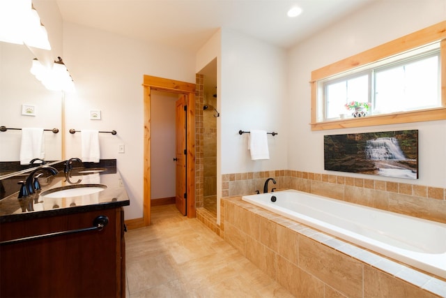 bathroom featuring a shower stall, a bath, double vanity, and a sink