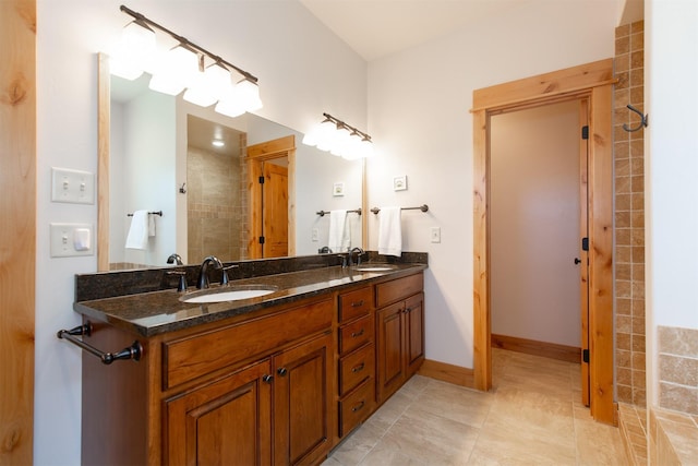 full bath featuring a sink, double vanity, baseboards, and tile patterned floors