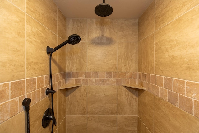 interior details featuring tiled shower