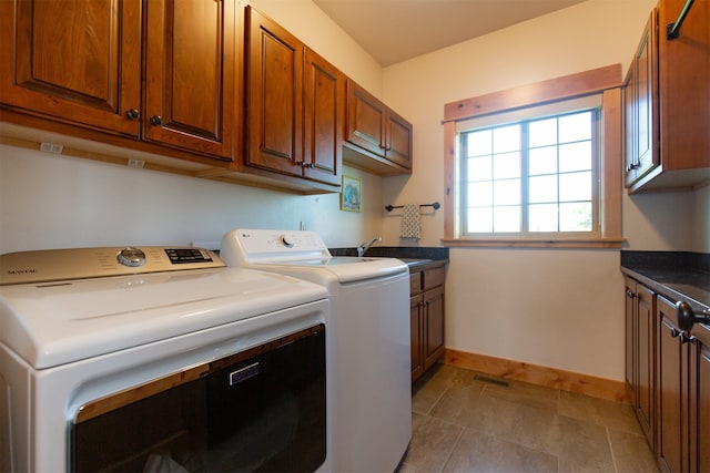 clothes washing area with a sink, cabinet space, washer and clothes dryer, visible vents, and baseboards