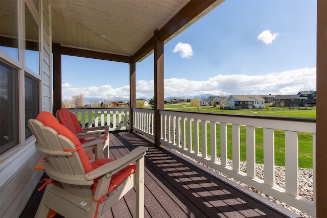 wooden terrace with a lawn and a residential view