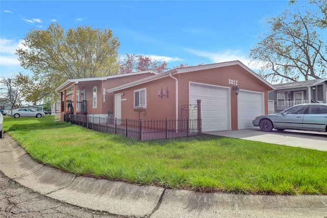 view of side of property featuring a yard, driveway, fence, a garage, and stucco siding