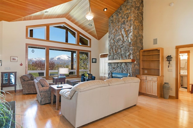 406 Back Nine Ln, Hamilton, MT 59840 - living area with high vaulted ceiling, visible vents, a fireplace, light wood finished floors, and wooden ceiling