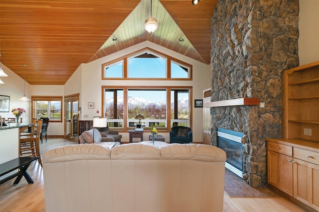406 Back Nine Ln, Hamilton, MT 59840 - living area featuring a stone fireplace, light wood-style flooring, and vaulted ceiling