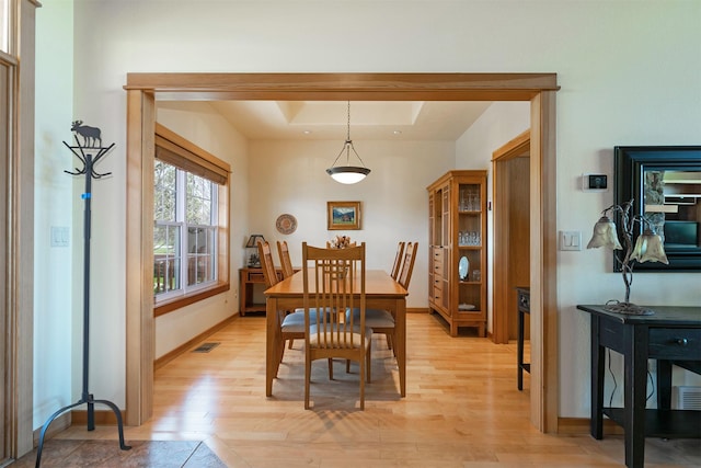 406 Back Nine Ln, Hamilton, MT 59840 - dining space featuring a tray ceiling, light wood-style floors, visible vents, and baseboards
