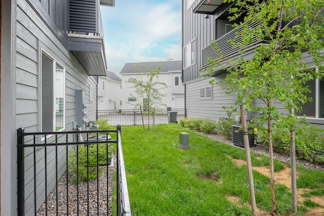 view of yard with fence and central AC