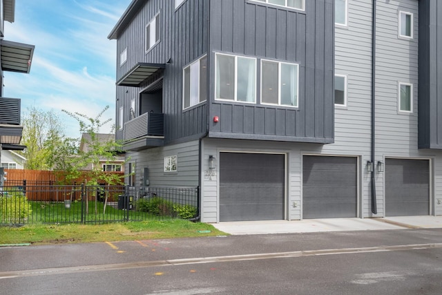 view of front of house with fence, a garage, and board and batten siding