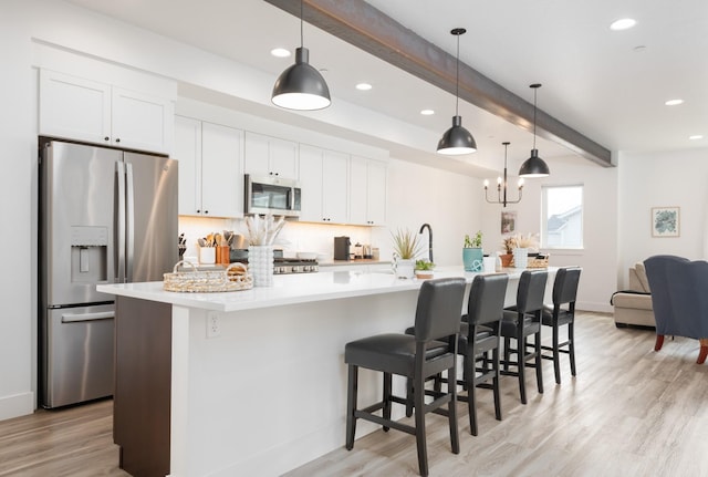 kitchen with a large island with sink, light wood-type flooring, recessed lighting, white cabinetry, and appliances with stainless steel finishes