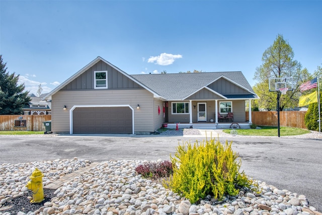 ranch-style home featuring a porch, fence, driveway, and board and batten siding