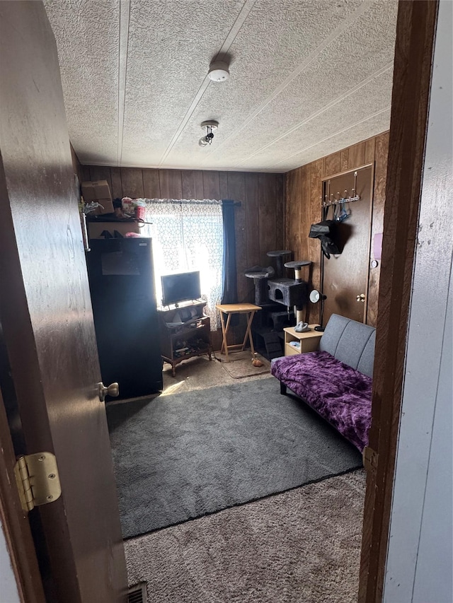 bedroom with wood walls and carpet floors