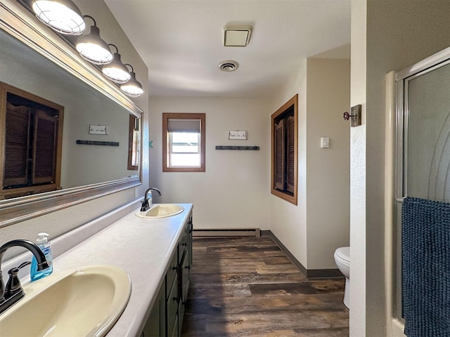 101 11th Ave N, Shelby, MT 59474 - full bathroom with visible vents, wood finished floors, a baseboard heating unit, and a sink