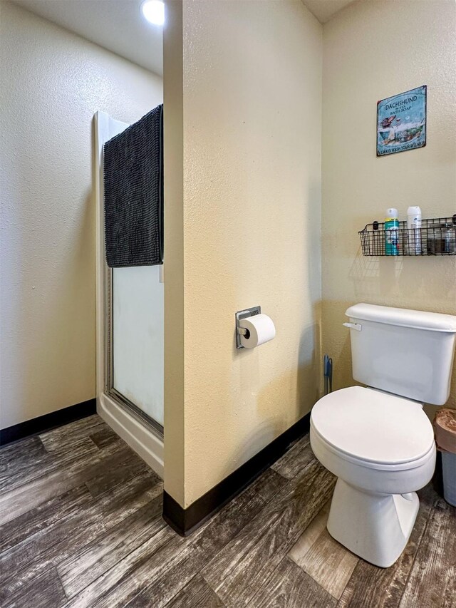 101 11th Ave N, Shelby, MT 59474 - full bathroom featuring toilet, baseboards, a shower stall, and wood finished floors