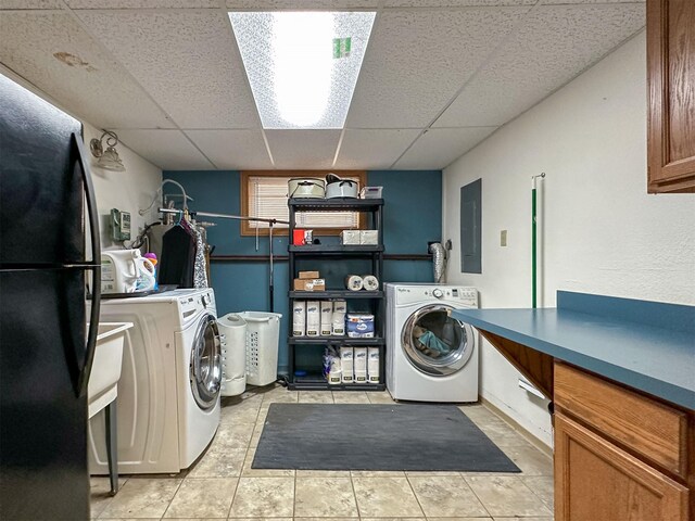 101 11th Ave N, Shelby, MT 59474 - washroom featuring electric panel, washing machine and clothes dryer, light tile patterned flooring, and cabinet space