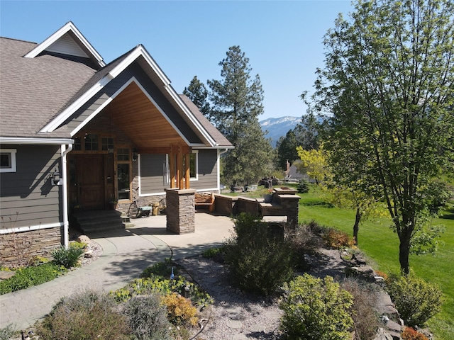 34426 Ridge Rd, Polson, MT 59860 - view of property exterior featuring stone siding and roof with shingles