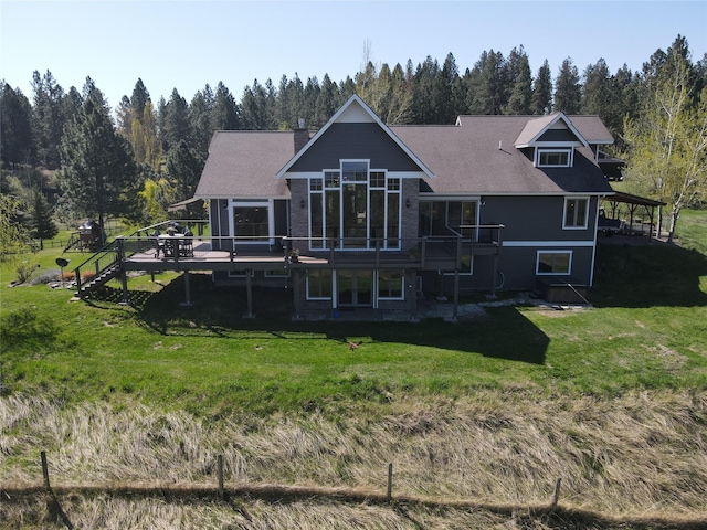 34426 Ridge Rd, Polson, MT 59860 - back of property with a wooden deck, a lawn, and a wooded view