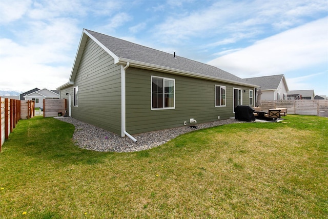 back of house with a lawn and a fenced backyard