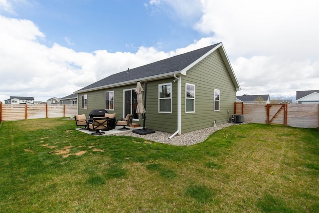 rear view of property with a lawn, a patio area, and a fenced backyard