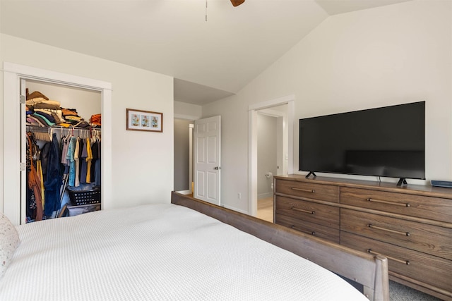 bedroom with a closet, a walk in closet, baseboards, ceiling fan, and lofted ceiling