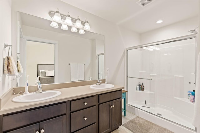 full bathroom with a sink, a shower stall, and visible vents