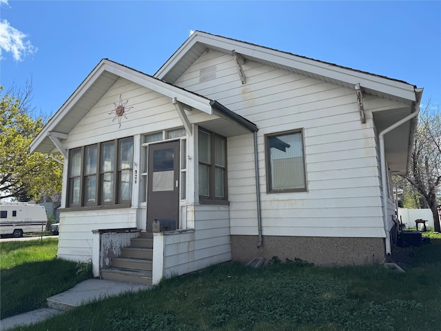 926 8th Ave N, Great Falls, MT 59401 - bungalow-style house with entry steps, a sunroom, and a front lawn