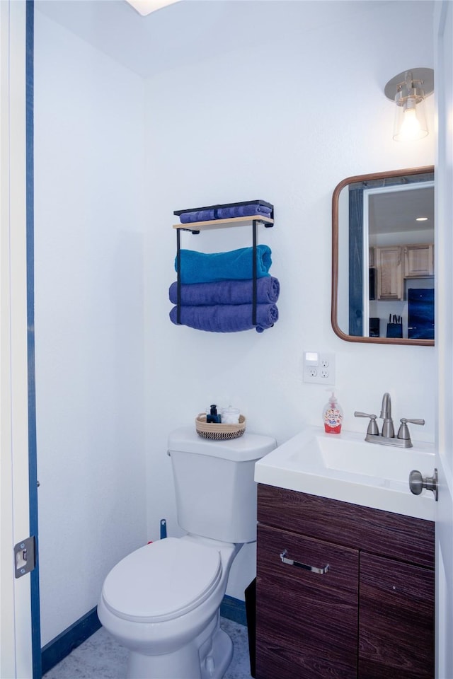 bathroom with toilet, baseboards, and vanity
