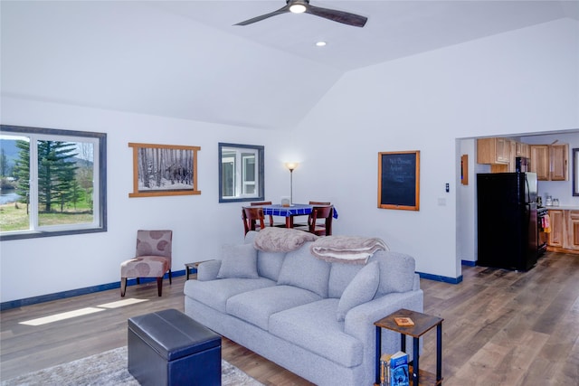 living room featuring wood finished floors, baseboards, ceiling fan, lofted ceiling, and recessed lighting
