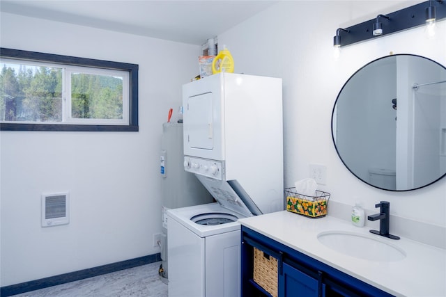 bathroom featuring baseboards, vanity, and stacked washer / drying machine
