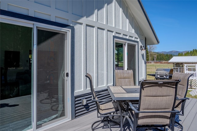deck with grilling area, outdoor dining space, and a mountain view