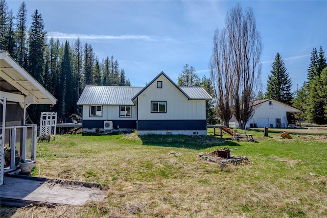back of property featuring a lawn, metal roof, and a fire pit