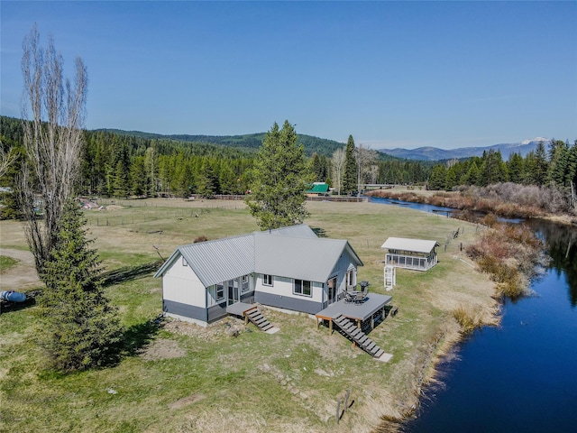 drone / aerial view with a wooded view and a water and mountain view