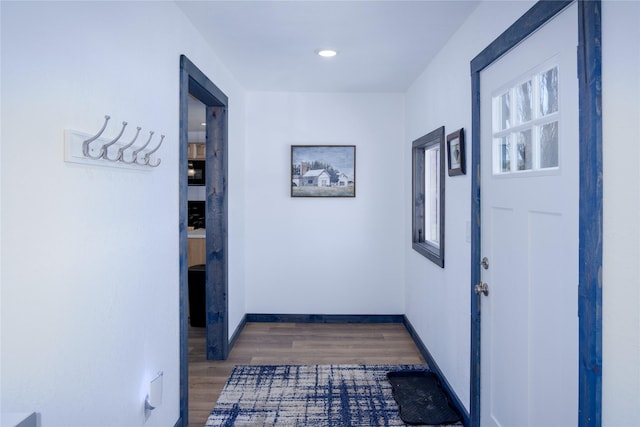 corridor with recessed lighting, baseboards, and wood finished floors