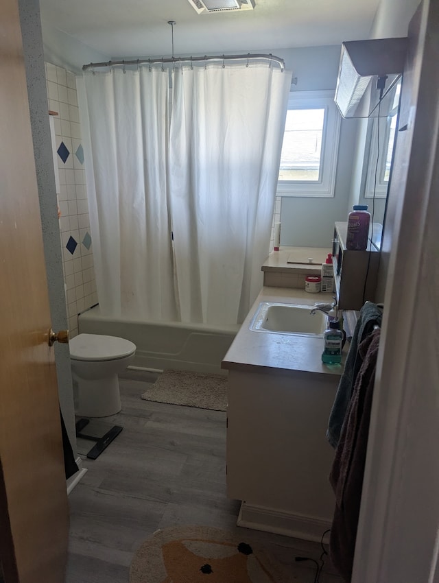 412 Raymond St, Helena, MT 59601 - full bath featuring toilet, vanity, wood finished floors, and shower / bath combo with shower curtain