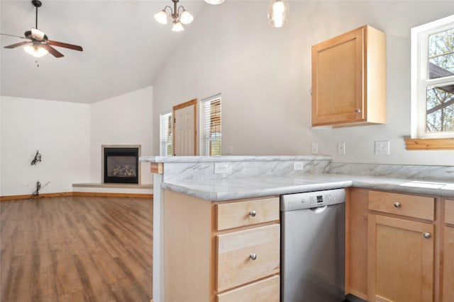 3010 Tina Ave Unit 306, Missoula, MT 59808 - kitchen with stainless steel dishwasher, vaulted ceiling, wood finished floors, a fireplace with raised hearth, and light brown cabinetry