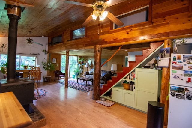 interior space with wood ceiling, light wood-style flooring, freestanding refrigerator, ceiling fan, and stairs