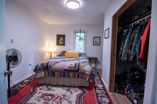 bedroom featuring a closet, wood finished floors, and baseboards