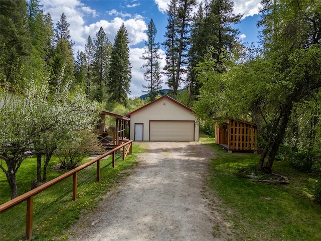 view of front of property featuring an outdoor structure, a garage, and fence