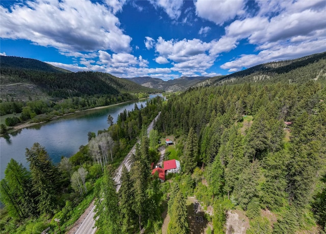 birds eye view of property featuring a wooded view and a water and mountain view