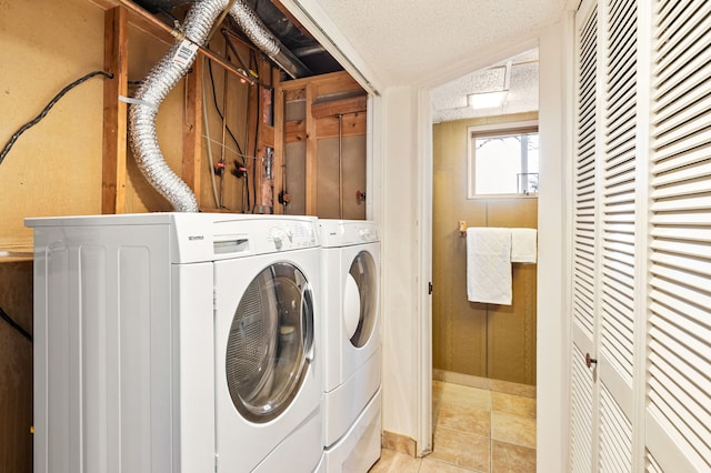 washroom featuring laundry area, washer and clothes dryer, and light tile patterned floors