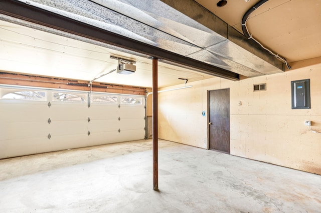 garage featuring electric panel, visible vents, and a garage door opener
