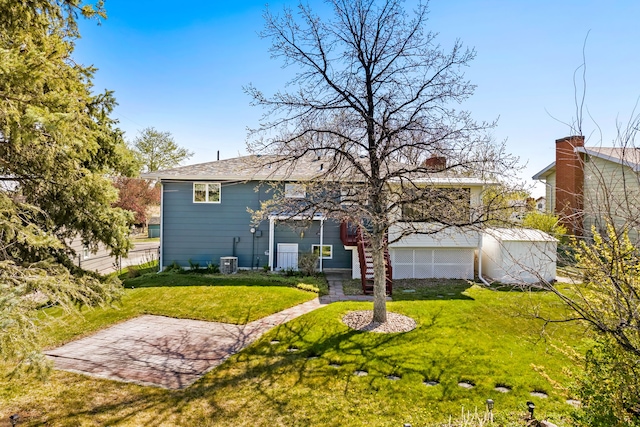 rear view of property with central air condition unit, a yard, and fence