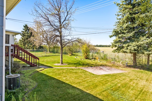 view of yard featuring central AC unit, stairs, a patio, and a fenced backyard