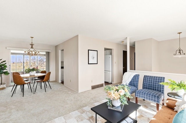 living room featuring a notable chandelier, visible vents, and carpet floors