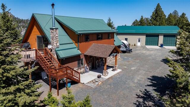 45 Bay Rd, Whitehall, MT 59759 - rustic home featuring stairway, a deck, a garage, and metal roof