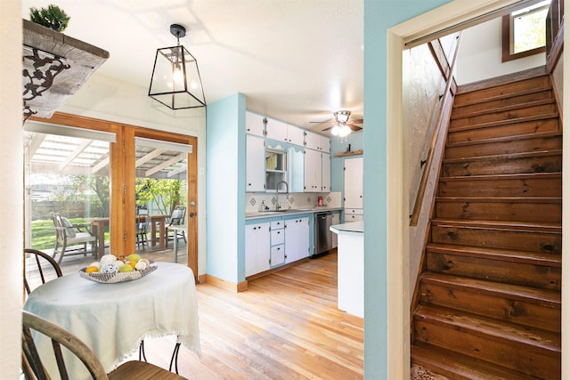 dining room with stairs, ceiling fan, and light wood-type flooring