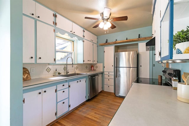 kitchen with a ceiling fan, a sink, backsplash, light countertops, and appliances with stainless steel finishes